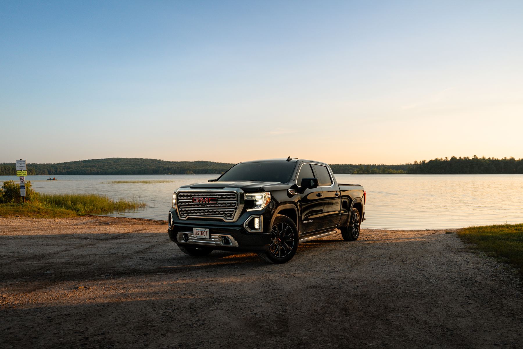 Selected frame: black pickup at the lake at sunset